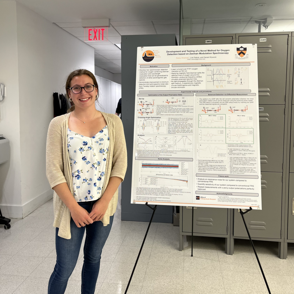 Woman is standing next to a research poster at a poster presentation session