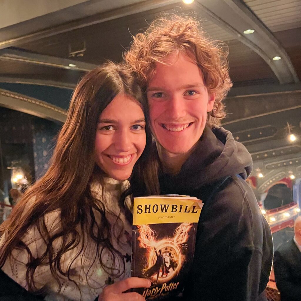 Photo taken by Whitman College Council; depicts two young individuals smiling at the camera holding the showbill for Harry Potter