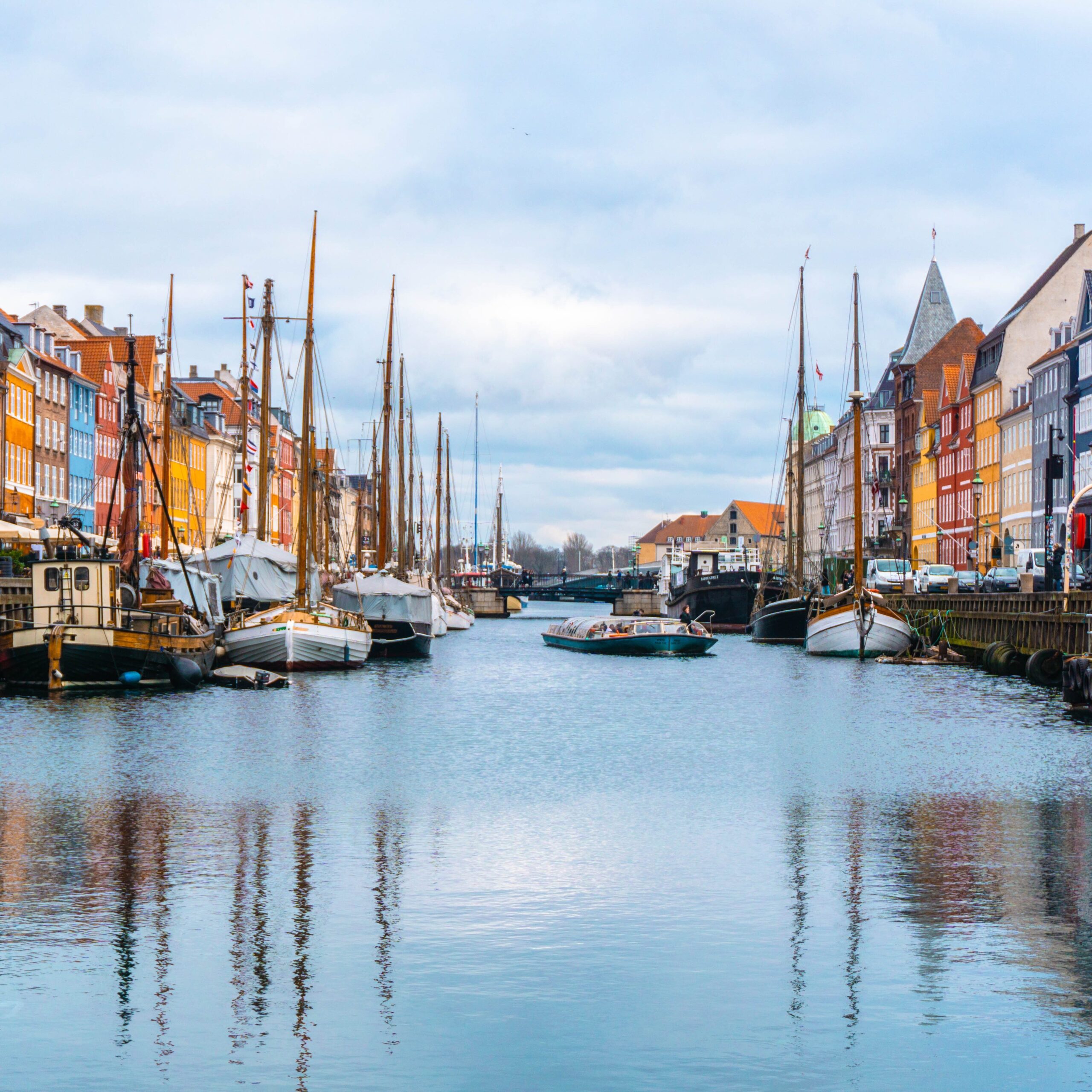 Colorful buildings on either side of a canal with boats moored in it.