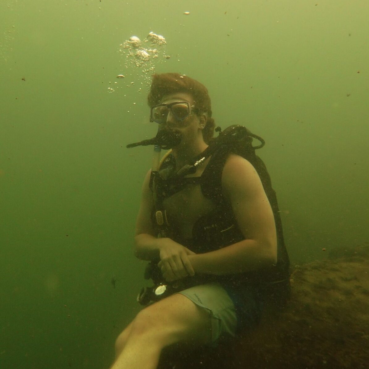 Tom Silldorff goofily posing for a photo while underwater scuba diving. 