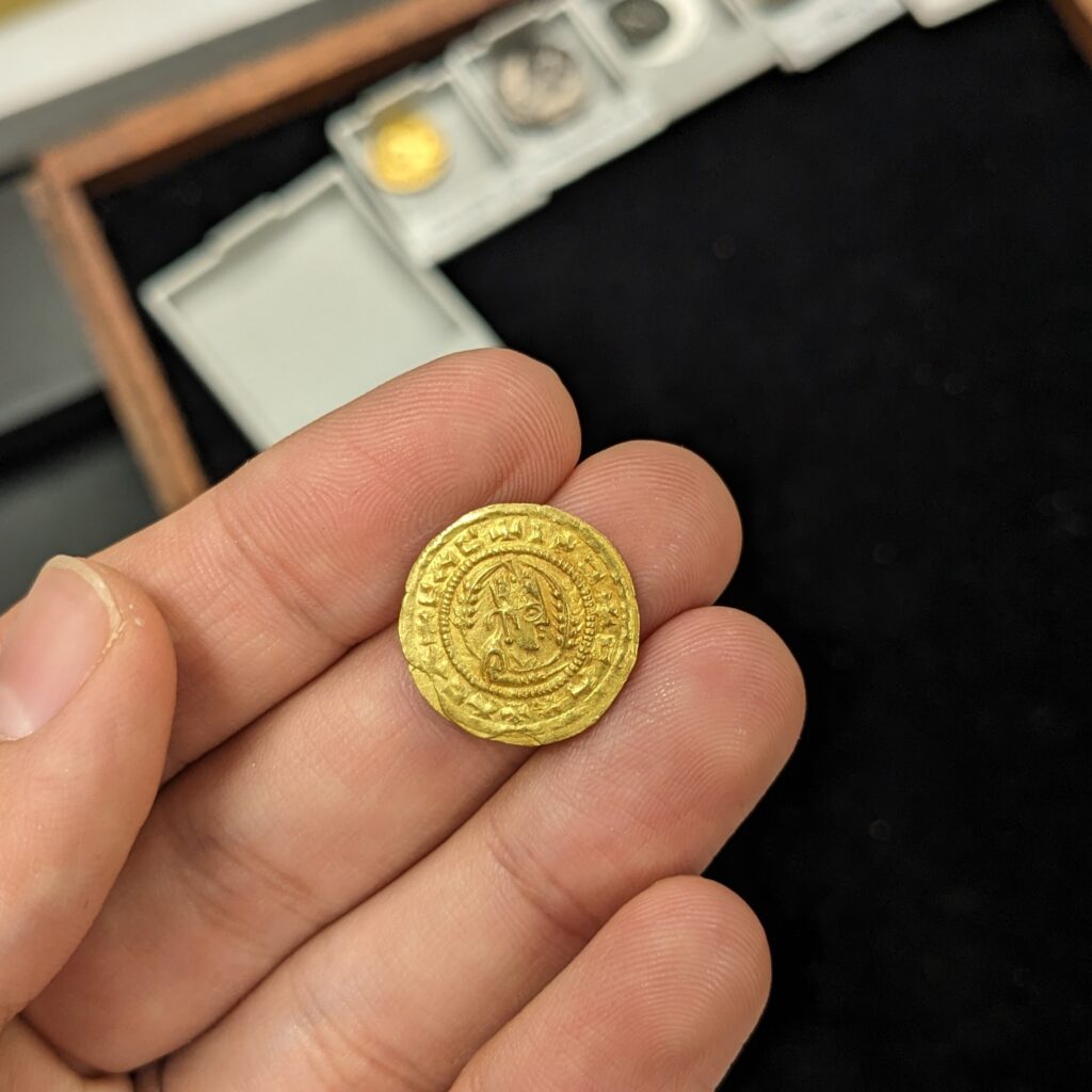 A small gold coin in the photographer's left hand.
