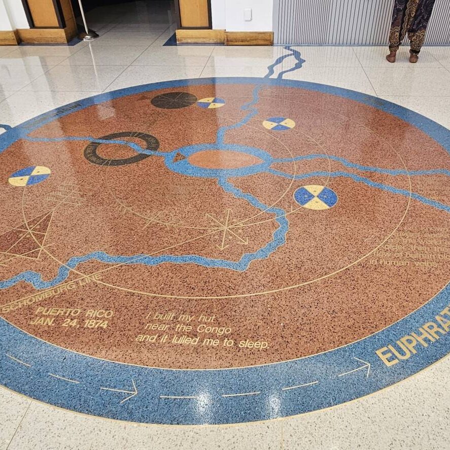 A picture of the art installation "Rivers," which depicts river lines flowing out of a blue oval and intersecting with various words and symbols.