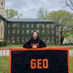 Rebecca Cho standing in front of the GEO banner in front of Nassau Hall.