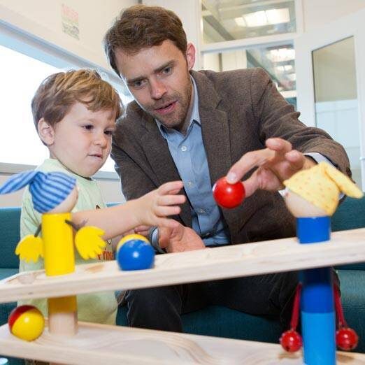 Princeton Baby Lab Professor Casey Lew-Williams playing with a toddler visiting the Baby lab.