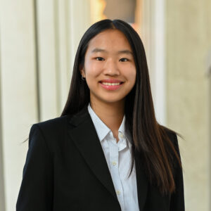 Photograph of young woman in suite with long hair smiling at camera