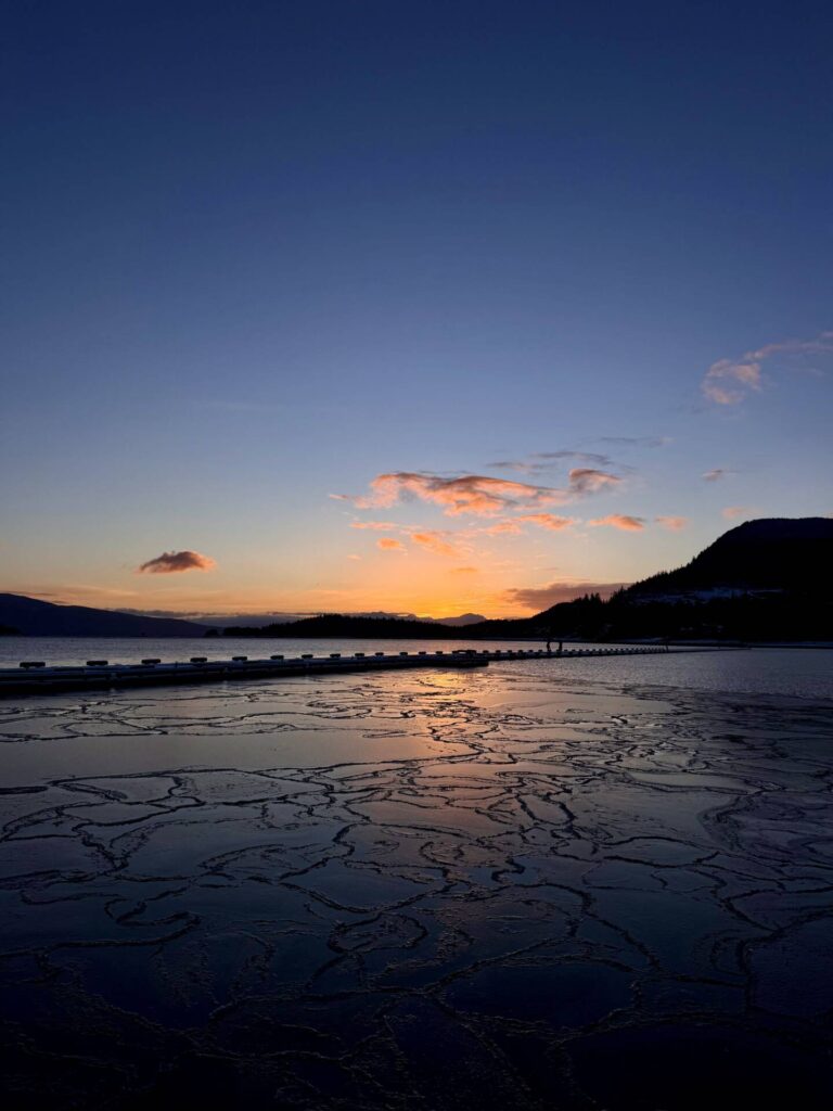 Sunset over Auk Bay Harbor with ice fractals atop the water